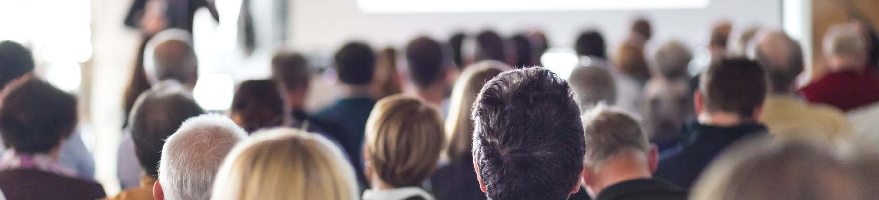 a group of people in a room showing only the back of their head